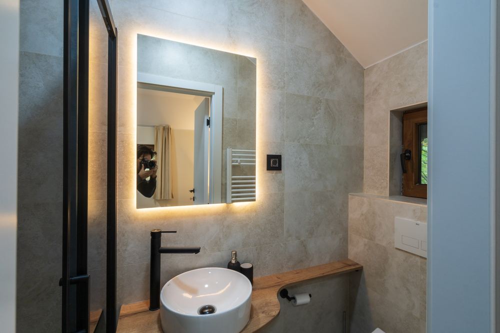 Lavabo i osvetljeno ogledalo u kupatilu sobe N1